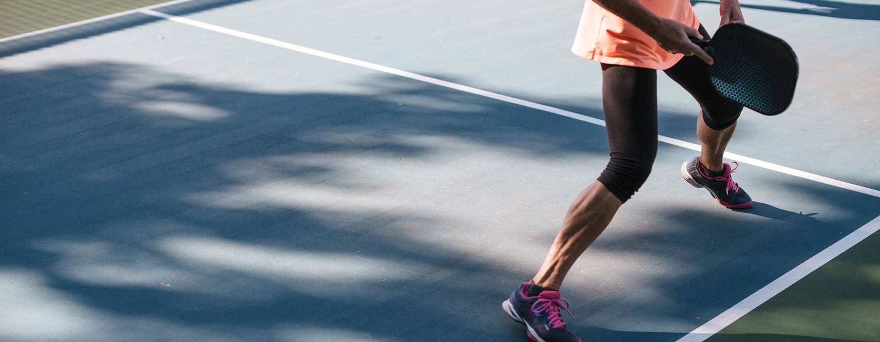 woman playing pickleball on a court