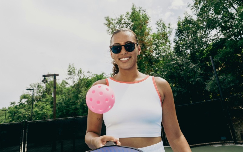 woman playing pickleball on a court